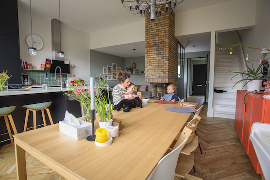 vrouw zit met twee kinderen aan tafel 