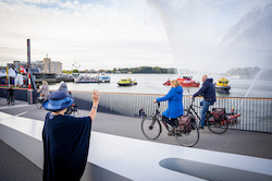 Wuivende Beatrix naar fietsers tijdens de opening van de Prins Clausbrug